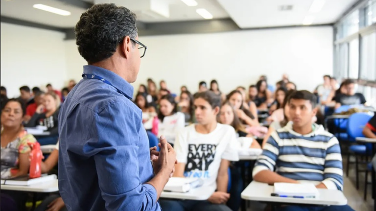 Professor orienta estudantes em sala de aula sobre como consultar cursos reconhecidos pelo Ministério da Educação.
